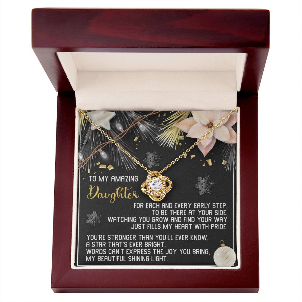 Introducing the Daughter-Shining Light - Love Knot Necklace, showcasing a heart pendant with gleaming cubic zirconia crystals. This exquisite necklace is nestled in a wooden box adorned with floral and star designs, making it the ideal personalized gift that blends elegance with heartfelt sentiment for your daughter.