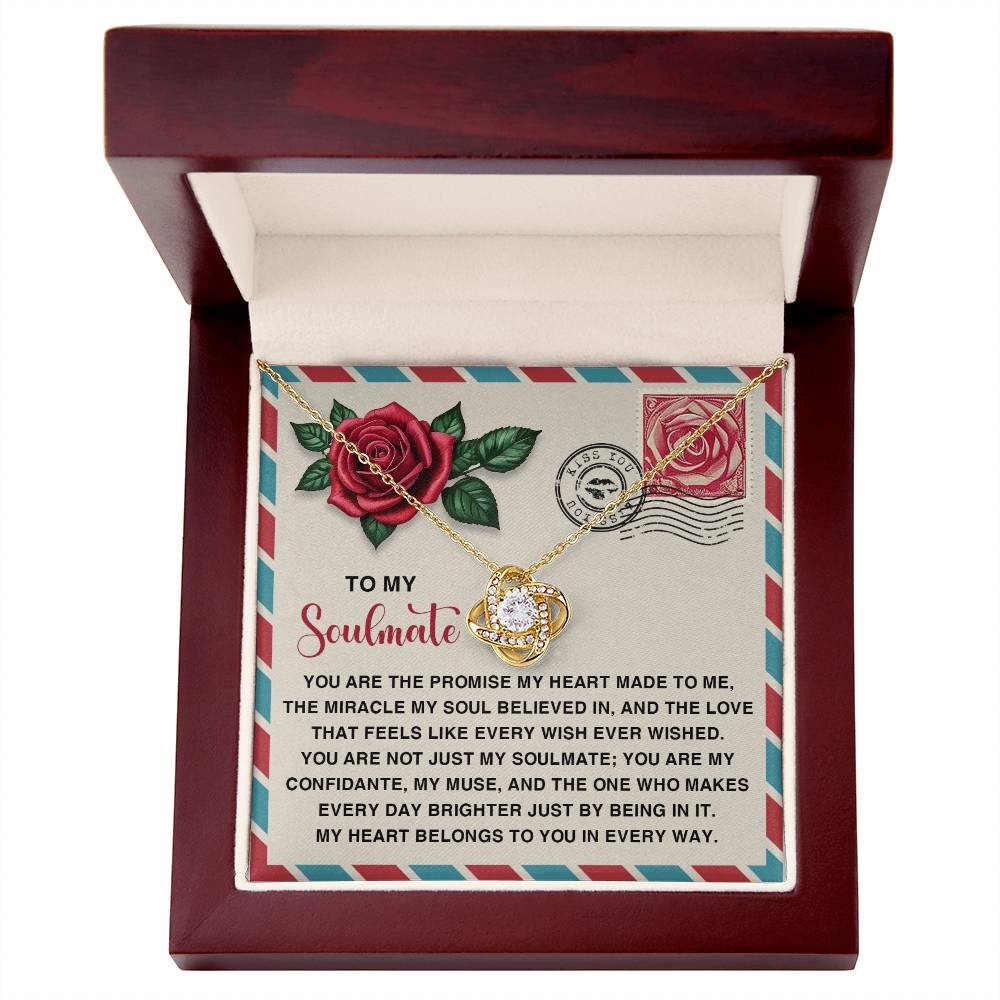 The Soulmate-Made To Me - Love Knot Necklace, with a round pendant embellished with cubic zirconia, is elegantly presented in a wooden box. The lid features a vibrant note adorned with roses and stamps, titled "To my Soulmate.