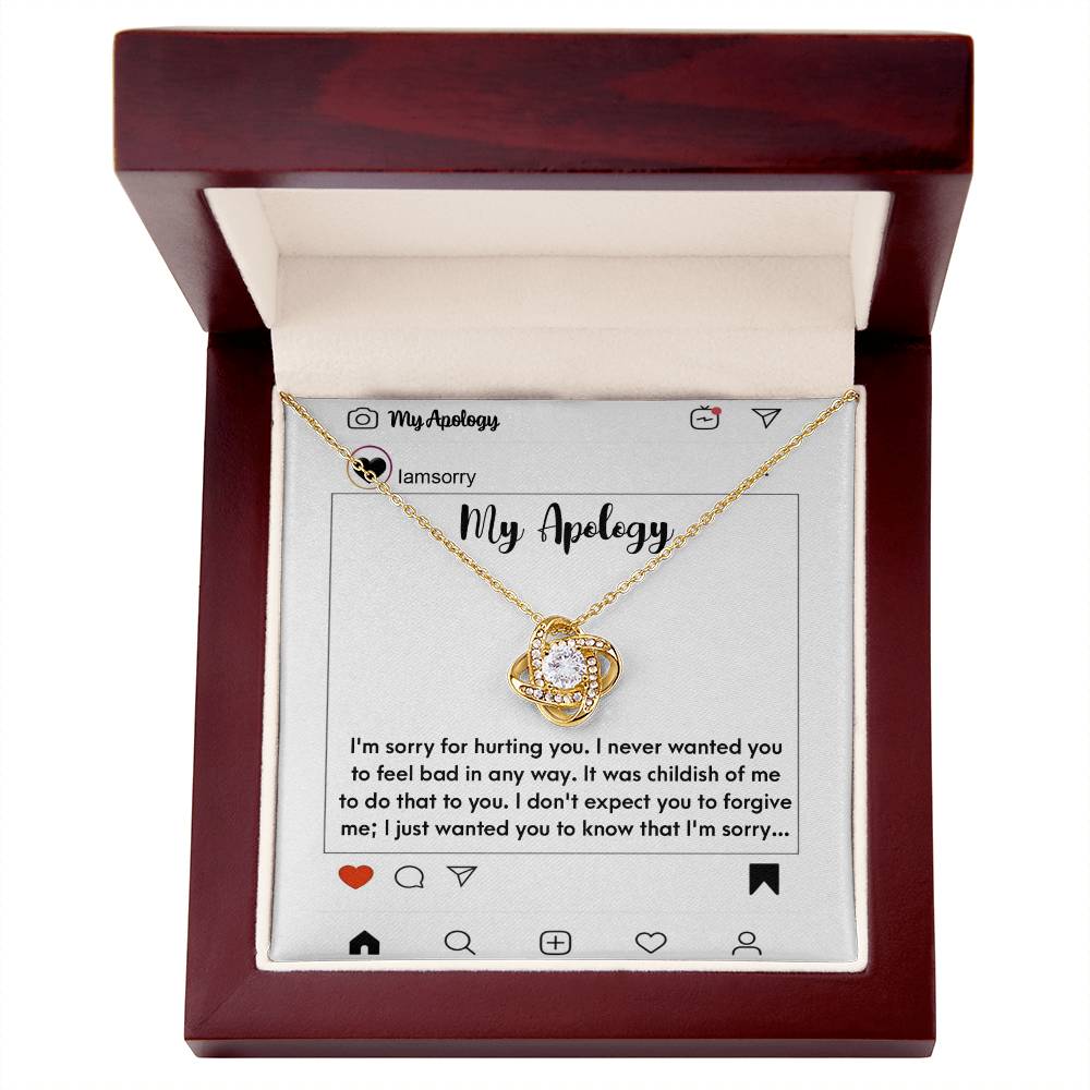 The "Sorry-My Apology - Love Knot Necklace," featuring a white gold finish and sparkling cubic zirconia crystals, is elegantly displayed in a box. The background includes an emotional apology message presented as a simulated social media post.