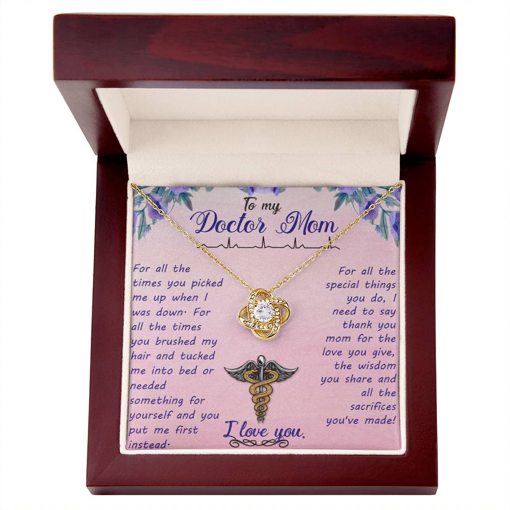 An open jewelry box with a heartfelt printed message for a mother who is a doctor, featuring the To My Doctor Mom, For All The Times You Picked Me Up - Love Knot Necklace by ShineOn Fulfillment on a floral background.