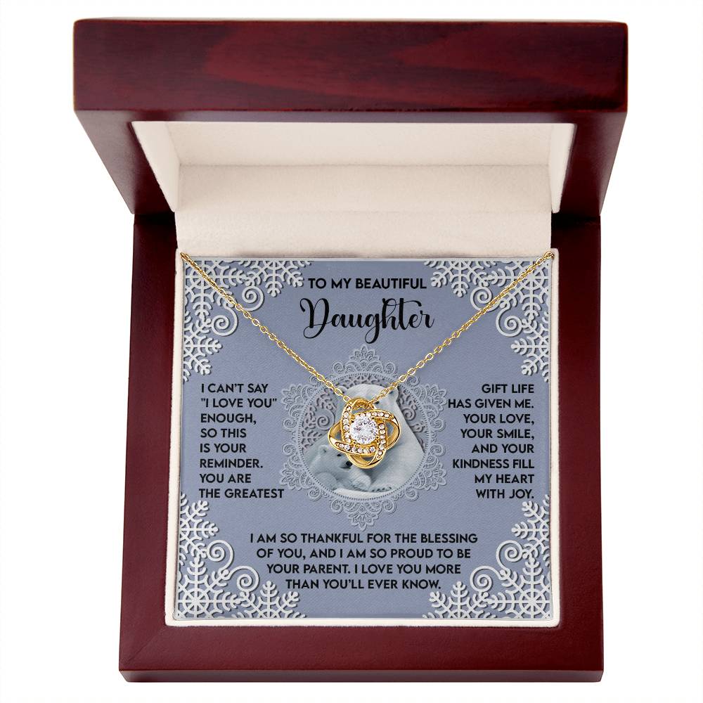 Presented in an open jewelry box, the Daughter-Fill My Heart - Love Knot Necklace showcases a circular pendant embellished with shimmering cubic zirconia and includes a heartfelt message for a daughter. This personalized gift is ideal for treasuring forever.