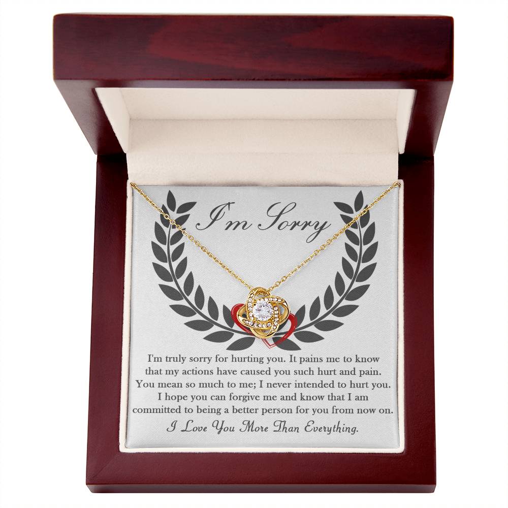 A personalized gift, the Sorry-From Now On - Love Knot Necklace comes in a red and wooden box. The inside lid of the box displays an 'I'm Sorry' note with a heartfelt apology message, while the pendant itself is adorned with dazzling cubic zirconia crystals.