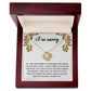 The "Sorry, Make It Right - Love Knot Necklace," featuring a silver intertwined knot pendant adorned with cubic zirconia crystals, is beautifully displayed in a box. The text on the box reads, "I’m sorry," with an apology message below, framed by a floral border in the top corners.