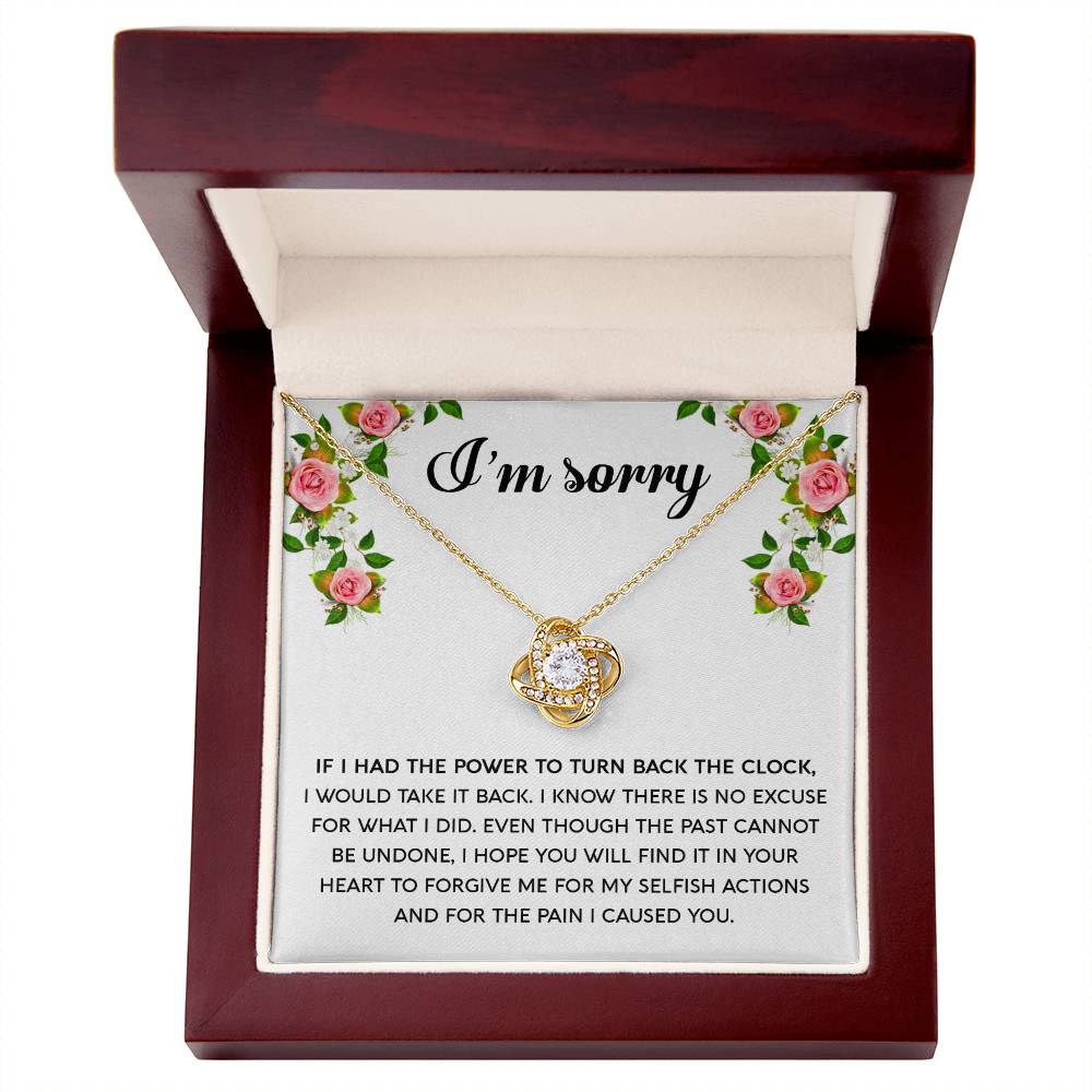 The "Sorry, Make It Right - Love Knot Necklace," featuring a silver intertwined knot pendant adorned with cubic zirconia crystals, is beautifully displayed in a box. The text on the box reads, "I’m sorry," with an apology message below, framed by a floral border in the top corners.