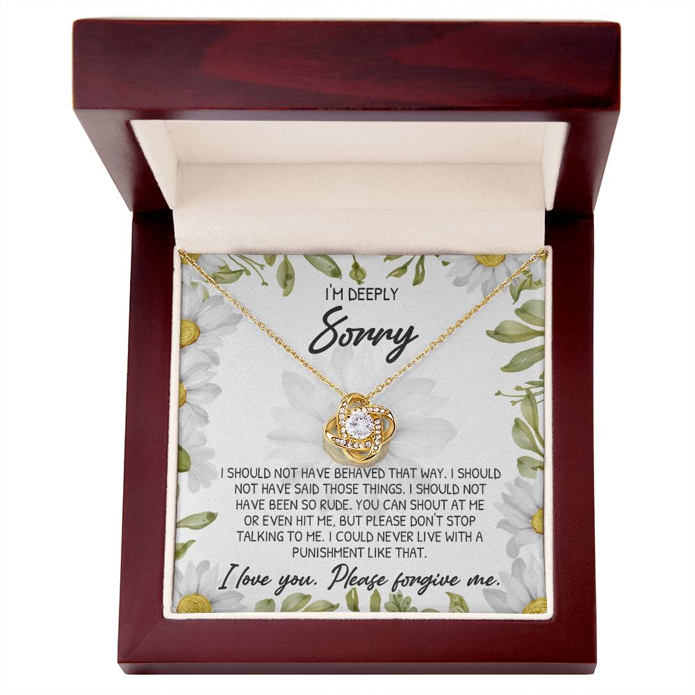 A personalized gift, the "Sorry-Please Don't Top - Love Knot Necklace" features a gold circular pendant adorned with cubic zirconia crystals and comes in a wooden box. The box also includes an apology note expressing regret for past behavior and asking for forgiveness.