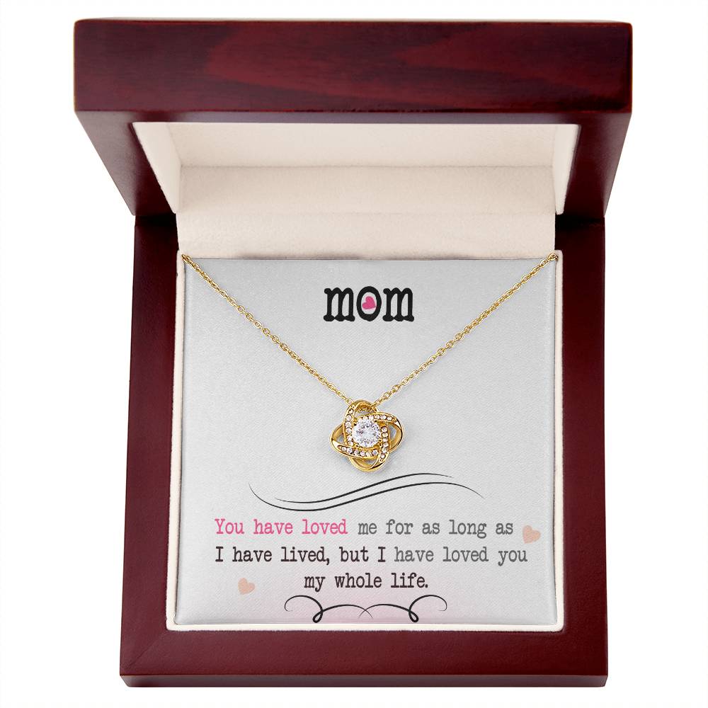 A gold finish "To My Mom, I Loved You My Whole Life - Love Knot Necklace" pendant necklace in a gift box with an affectionate message by ShineOn Fulfillment.