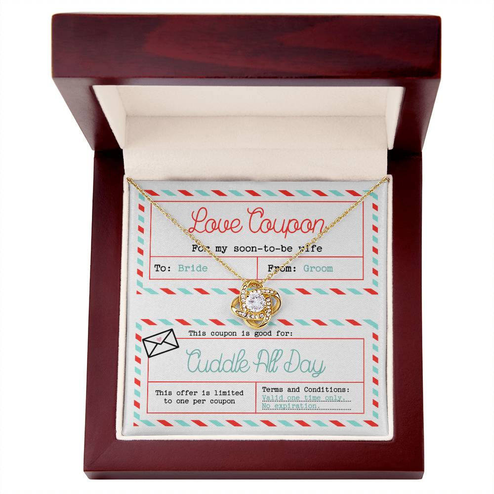 The "To Wife, Wedding-Love Coupon - Love Knot Necklace" adorned with cubic zirconia crystals sits atop a decorated card labeled "Love Coupon." The card, addressed to "Bride" from "Groom," offers a "Cuddle All Day" coupon with no expiration date—a perfect gift for a loved one.