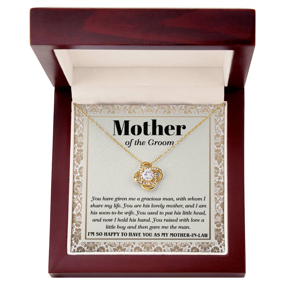 A "To Mother-In-Law, To Have You - Love Knot Necklace" with a heart-shaped pendant adorned with cubic zirconia crystals on a card labeled "Mother of the Groom" with a loving message expressing gratitude from the groom.