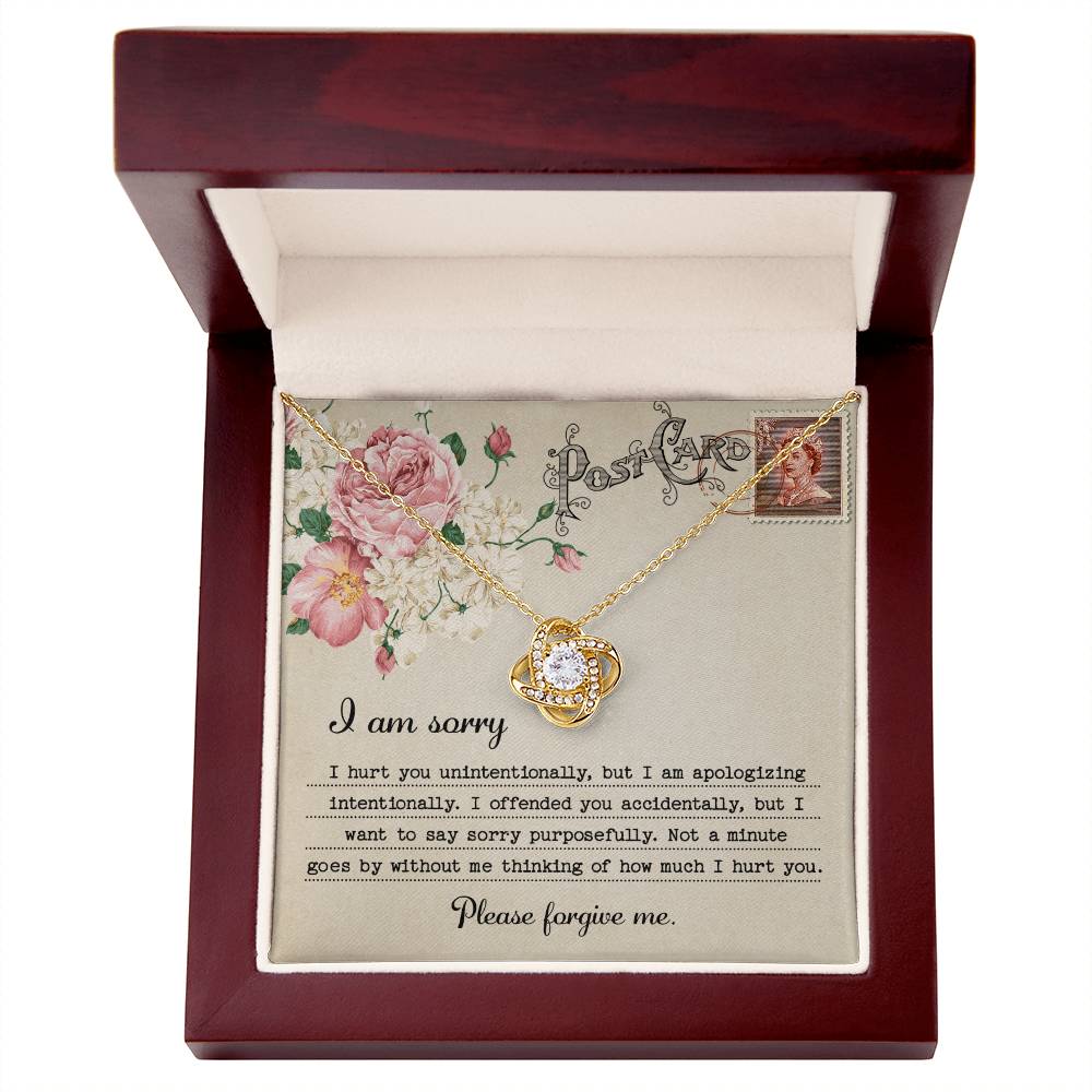 The "Sorry-Apologizing Intentionally - Love Knot Necklace," featuring a 14k white gold intertwined heart pendant, is beautifully presented on a card with a floral design that includes an apology note expressing heartfelt remorse and asking for forgiveness.