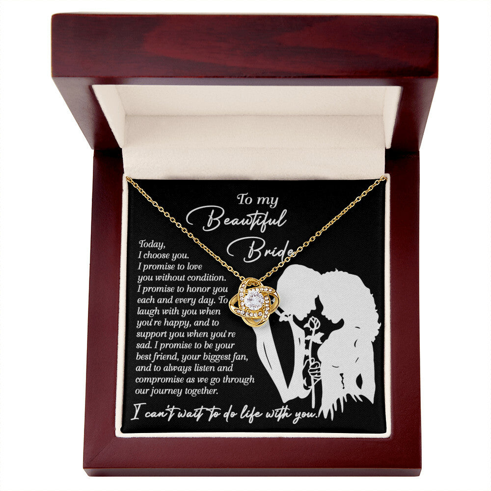 A To My Beautiful Bride, I Choose You - Love Knot Necklace with an intertwined design is displayed in a box. The box has a message to a bride expressing love and promises to honor, laugh, support, and be by her side through their journey together. The necklace features sparkling cubic zirconia crystals, making it a perfect personalized gift.