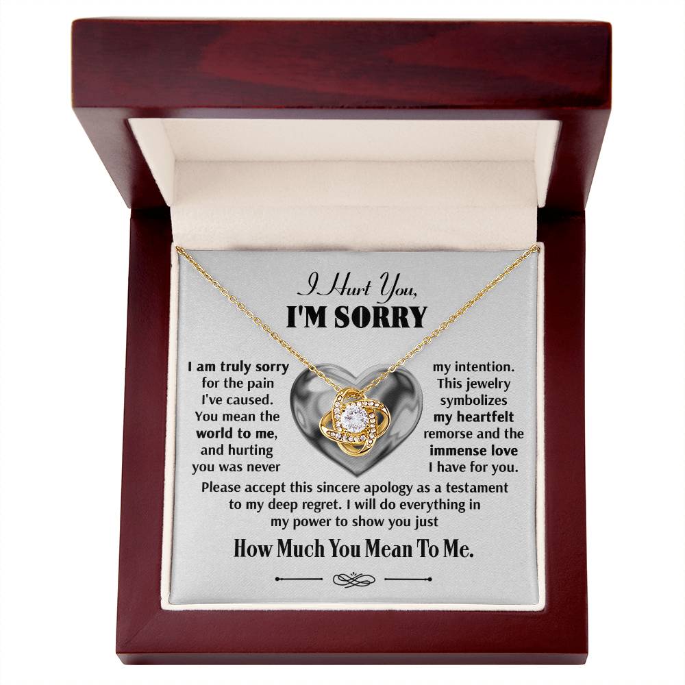 A jewelry box containing the Sorry-Sincere Apology - Love Knot Necklace, adorned with sparkling cubic zirconia crystals and accompanied by an apology message.