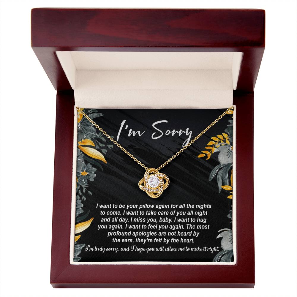 The "Sorry, Be Your Pillow - Love Knot Necklace" features an intertwined heart pendant adorned with cubic zirconia crystals. It comes in a gift box inscribed with "I'm Sorry" and includes a heartfelt apology message expressing regret and a desire for reconciliation.