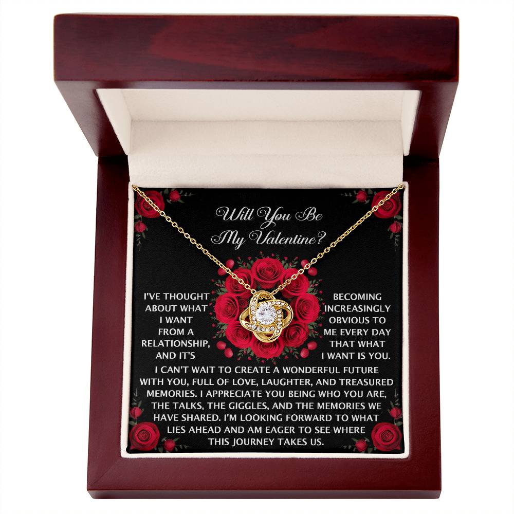 The Soulmate-What I Want - Love Knot Necklace, featuring a cubic zirconia stone, is displayed in an open wooden jewelry box with a romantic message and red rose graphics for an enchanting touch.