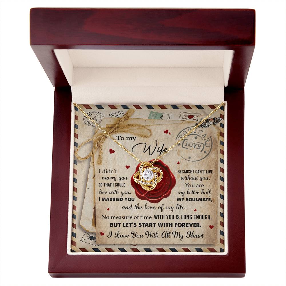 A "To Wife, Marry You - Love Knot Necklace" with an interlocking rings pendant, adorned with cubic zirconia crystals, displayed in a box featuring the background design of a love letter. The letter includes heartfelt messages for a wife, expressing love and commitment—a perfect personalized gift.