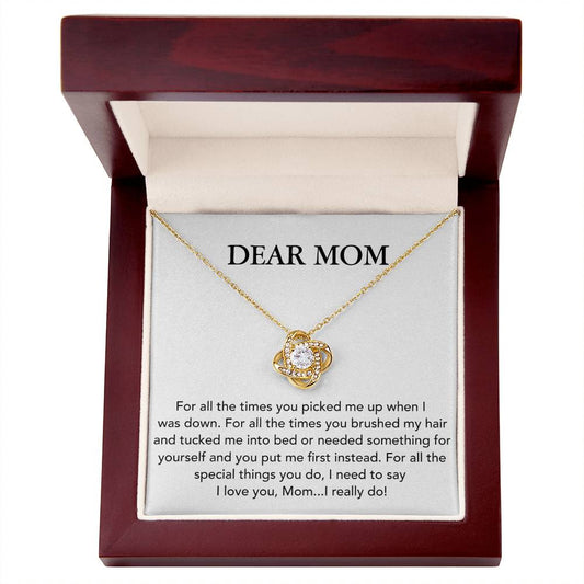 A "Dear Mom, For All The Times You Picked Me Up" Love Knot Necklace by ShineOn Fulfillment with adjustable chain length and cubic zirconia crystals is displayed inside a jewelry box that has an affectionate message addressed to "dear mom" on the interior of the lid.