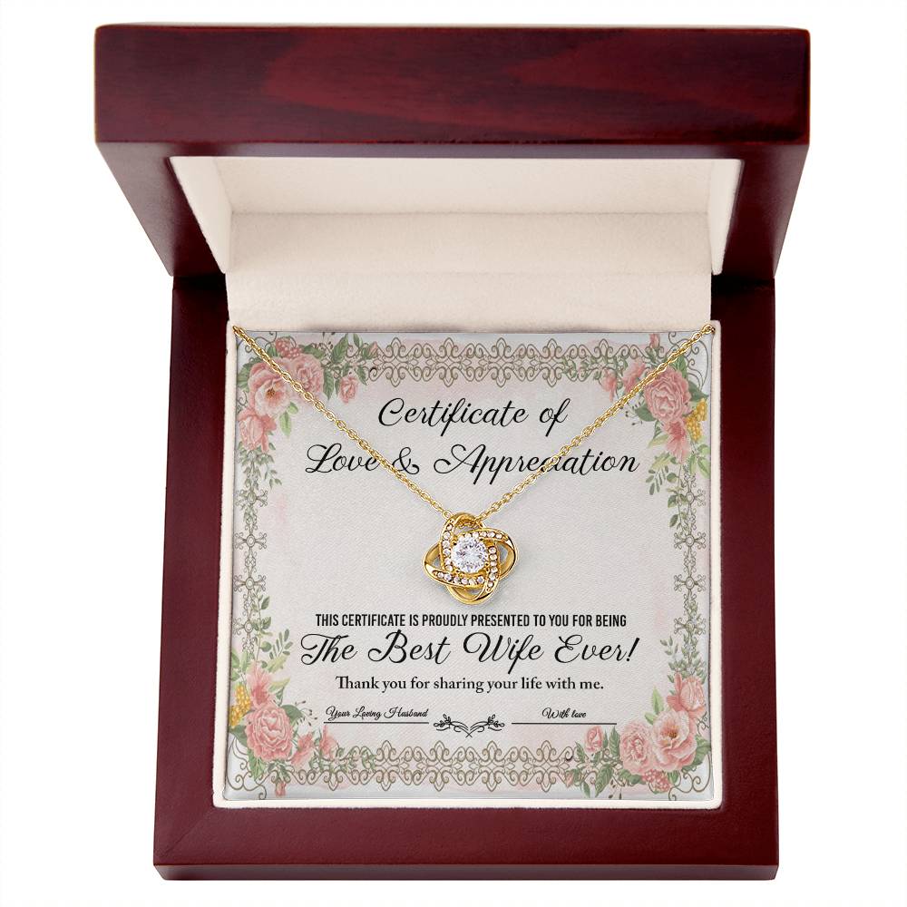 The "To Wife, Love & Appreciation - Love Knot Necklace" features a heart-shaped pendant elegantly displayed over a "Certificate of Love & Appreciation," expressing gratitude for being "The Best Wife Ever!" The necklace showcases a gold finish with sparkling cubic zirconia crystals, and the certificate is beautifully adorned with floral borders.