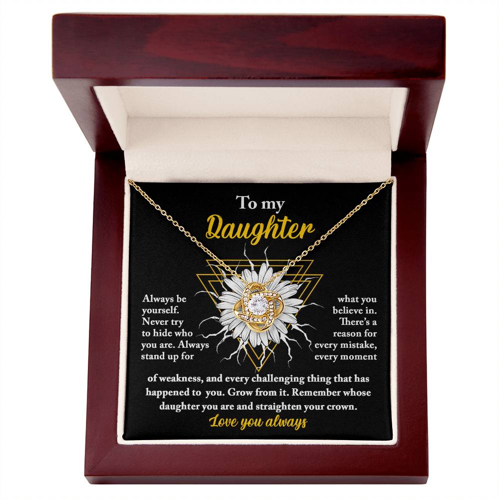 A personalized gift, this "To Daughter, Be Yourself - Love Knot Necklace" features a pendant encrusted with cubic zirconia crystals, nestled in a gift box. The box lid displays a heartfelt message addressed to "My Daughter," showcasing motivational and supportive text alongside a sunflower graphic.