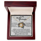 A Love Knot Necklace, featuring a circular pendant adorned with cubic zirconia stones, is beautifully nestled in a wooden box. The included card reads "To My Beautiful Granddaughter" and comes with a touching message. This necklace is aptly named the Granddaughter-Deeply Loved - Love Knot Necklace.