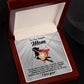 The Mom-A Fearless Woman - Love Knot Necklace features a heart-shaped pendant in an open wooden box. Behind it is a card inscribed with "To my Super Mom" and a superhero silhouette, adorned with sparkling cubic zirconia crystals for a personalized touch.