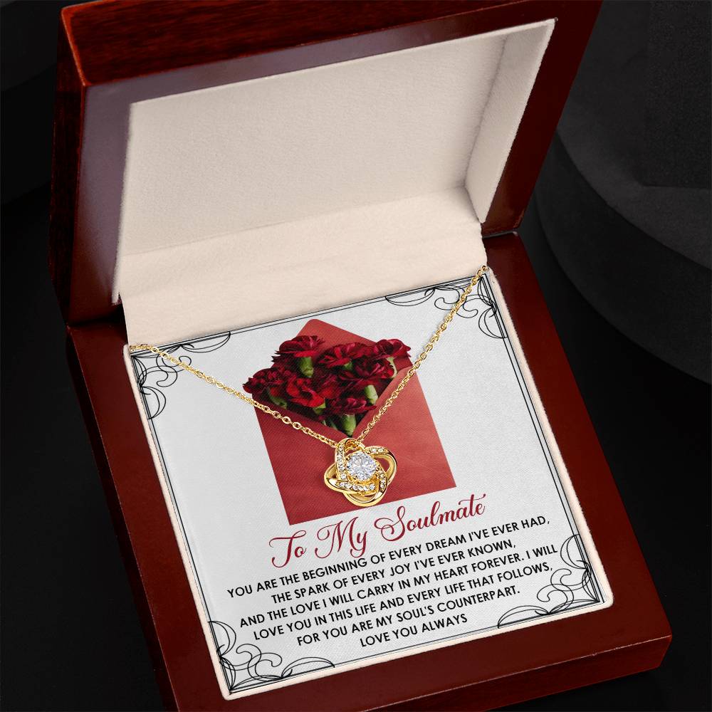 The open jewelry box showcases the Soulmate-My Heart Forever - Love Knot Necklace, sparkling with cubic zirconia crystals and a heart pendant. The lid displays a heartfelt note, "To My Soulmate," amid red roses, creating an ideal personalized gift for your beloved.