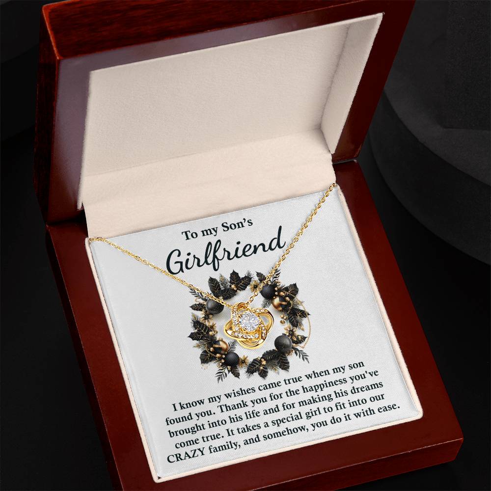 The Son's Girlfriend- Found You - Love Knot Necklace, showcasing a beautiful floral design embellished with cubic zirconia, is beautifully presented in an open box. Accompanying it is a touching message to a son's girlfriend, conveying gratitude and encouragement. An exceptionally personalized gift that represents lasting connection and appreciation.