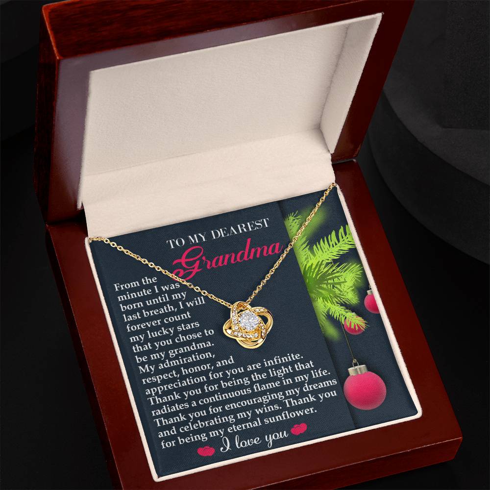 The Grandma-Eternal Sunflower - Love Knot Necklace, elegantly finished with white gold, is beautifully presented in a wooden box along with a heartfelt note for Grandma. The note, decorated with holiday-themed designs, conveys admiration and gratitude. The heart-shaped pendant is embellished with sparkling cubic zirconia, making it truly special.