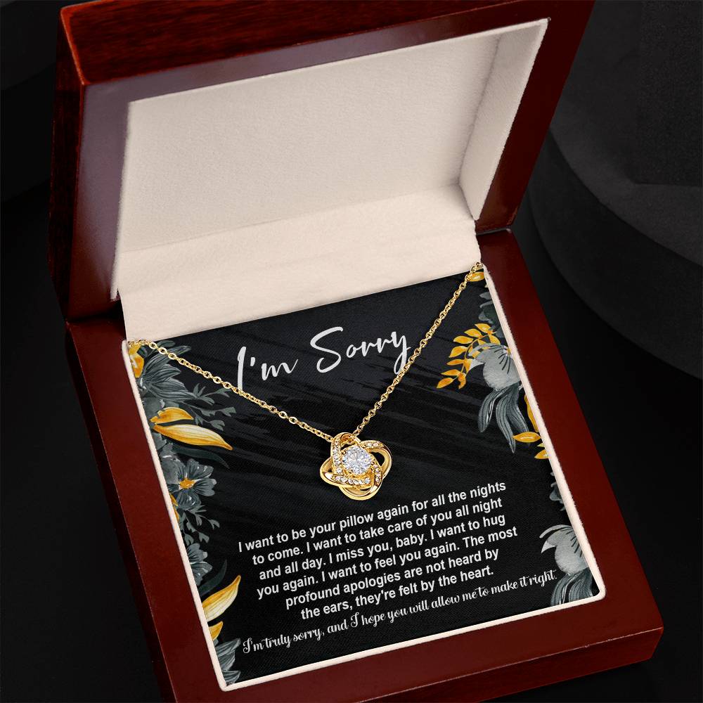 The "Sorry, Be Your Pillow - Love Knot Necklace" features an intertwined heart pendant adorned with cubic zirconia crystals. It comes in a gift box inscribed with "I'm Sorry" and includes a heartfelt apology message expressing regret and a desire for reconciliation.