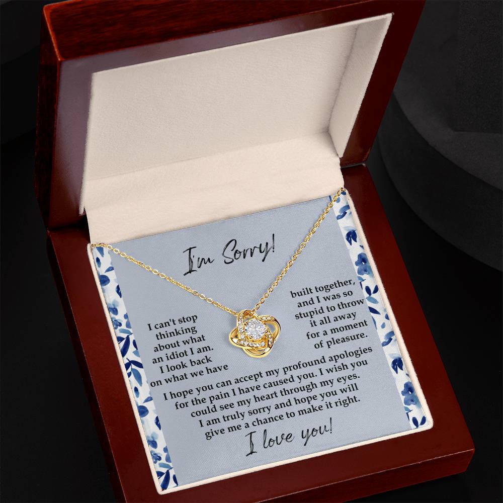 The "Sorry-Through My Eyes - Love Knot Necklace," adorned with cubic zirconia crystals and a white gold finish, is presented on a card featuring a heartfelt apology message, expressing regret for causing pain and seeking forgiveness.