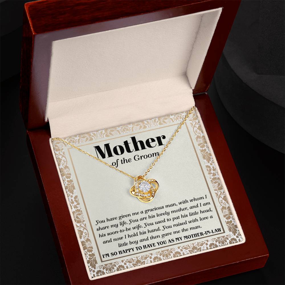 A "To Mother-In-Law, To Have You - Love Knot Necklace" with a heart-shaped pendant adorned with cubic zirconia crystals on a card labeled "Mother of the Groom" with a loving message expressing gratitude from the groom.