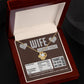 A To Wife, Nutrition Facts - Love Knot Necklace in a gift box that reads, "WIFE I LOVE YOU!" and "Thanks for being awesome!" It humorously lists nutritional facts like "Beauty 1000%" and "Not a significant source of regret," featuring sparkling cubic zirconia crystals with a stunning gold finish.