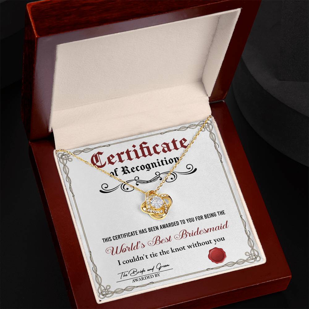 A stunning To Bridesmaid, Certificate Of Recognition - Love Knot Necklace in 14k white gold, adorned with cubic zirconia crystals, is displayed on a certificate that reads "World's Best Bridesmaid" awarded by the bride and groom.