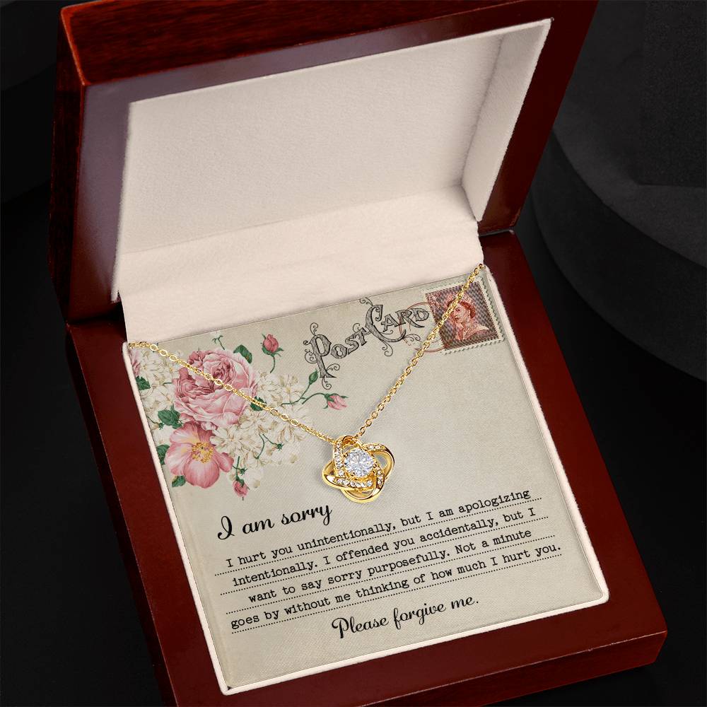 The "Sorry-Apologizing Intentionally - Love Knot Necklace," featuring a 14k white gold intertwined heart pendant, is beautifully presented on a card with a floral design that includes an apology note expressing heartfelt remorse and asking for forgiveness.