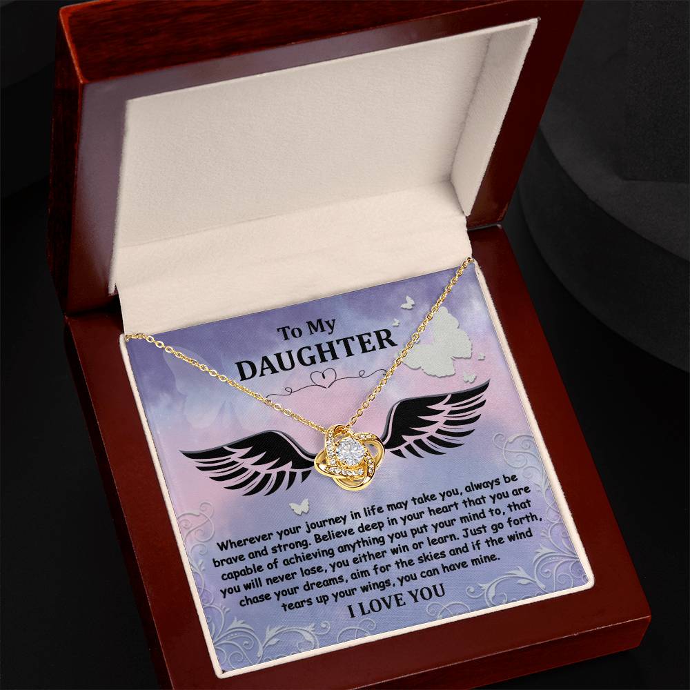 The "To Daughter, Brave And Strong - Love Knot Necklace" features a gold finish and a Cubic Zirconia pendant, beautifully displayed in a box. The box contains a heartfelt message titled "To My Daughter," encouraging bravery, strength, and the pursuit of dreams, and concludes with the words "I LOVE YOU.