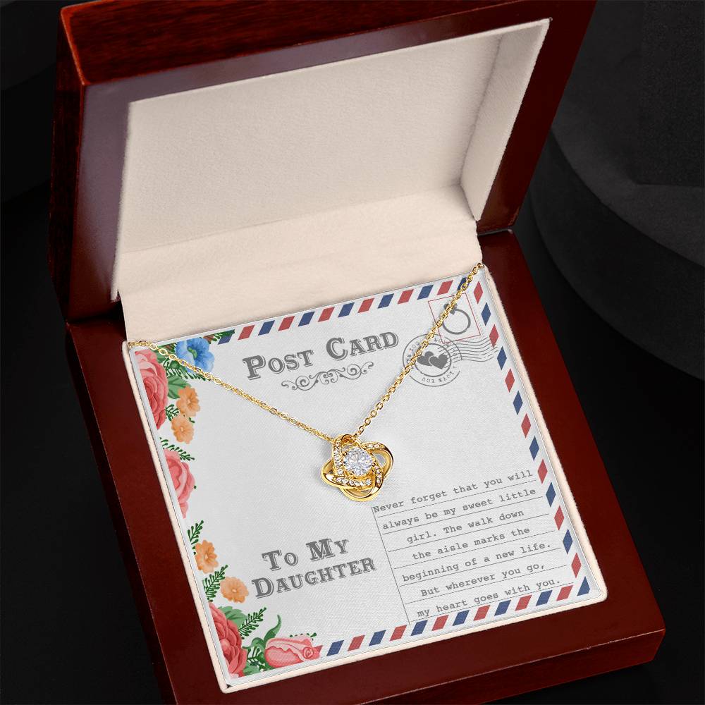 The "To Daughter, Goes With You - Love Knot Necklace," featuring an intertwining design with a gold finish and adorned with cubic zirconia crystals, is displayed on a postcard that reads "To My Daughter." The message includes a heartfelt note about your daughter's wedding and a mother's enduring love.