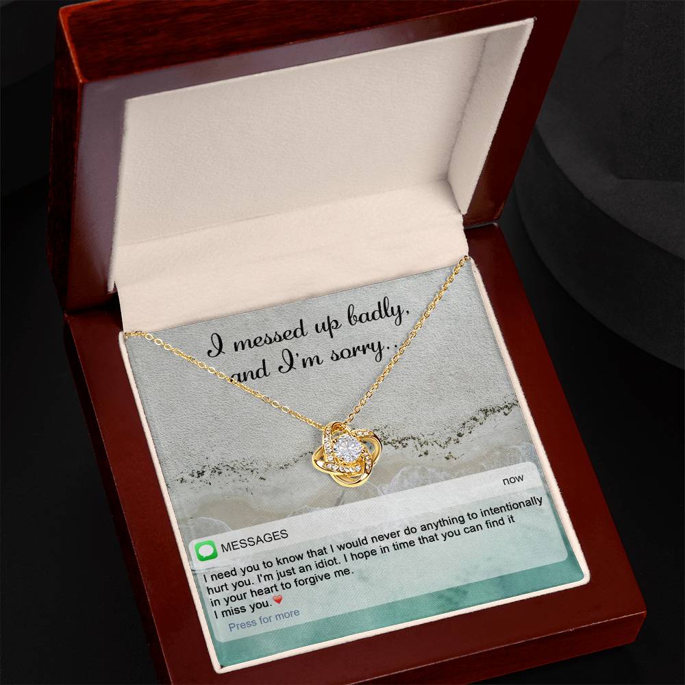 The "Sorry-Just An Idiot - Love Knot Necklace" features a heart-shaped pendant adorned with cubic zirconia crystals, presented on a card inscribed with "I messed up badly, and I'm sorry." It comes complete with a heartfelt text message expressing deep remorse and seeking forgiveness.