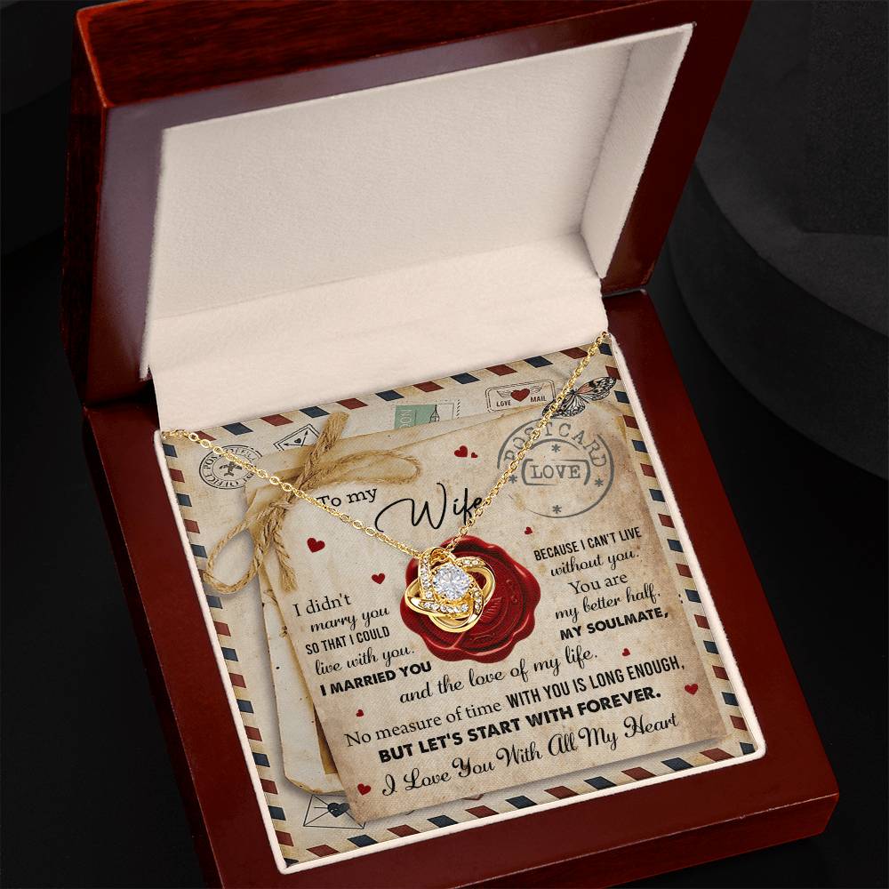 A "To Wife, Marry You - Love Knot Necklace" with an interlocking rings pendant, adorned with cubic zirconia crystals, displayed in a box featuring the background design of a love letter. The letter includes heartfelt messages for a wife, expressing love and commitment—a perfect personalized gift.