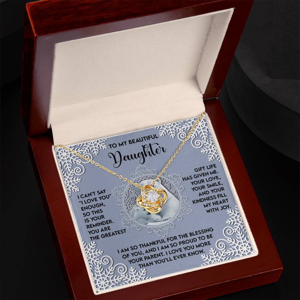 In an open box, the Daughter-Fill My Heart - Love Knot Necklace gleams with cubic zirconia and is accompanied by an ornate card that reads, "To my beautiful daughter," followed by a heartfelt message. This exquisite personalized gift beautifully embodies the profound love and devotion one feels.