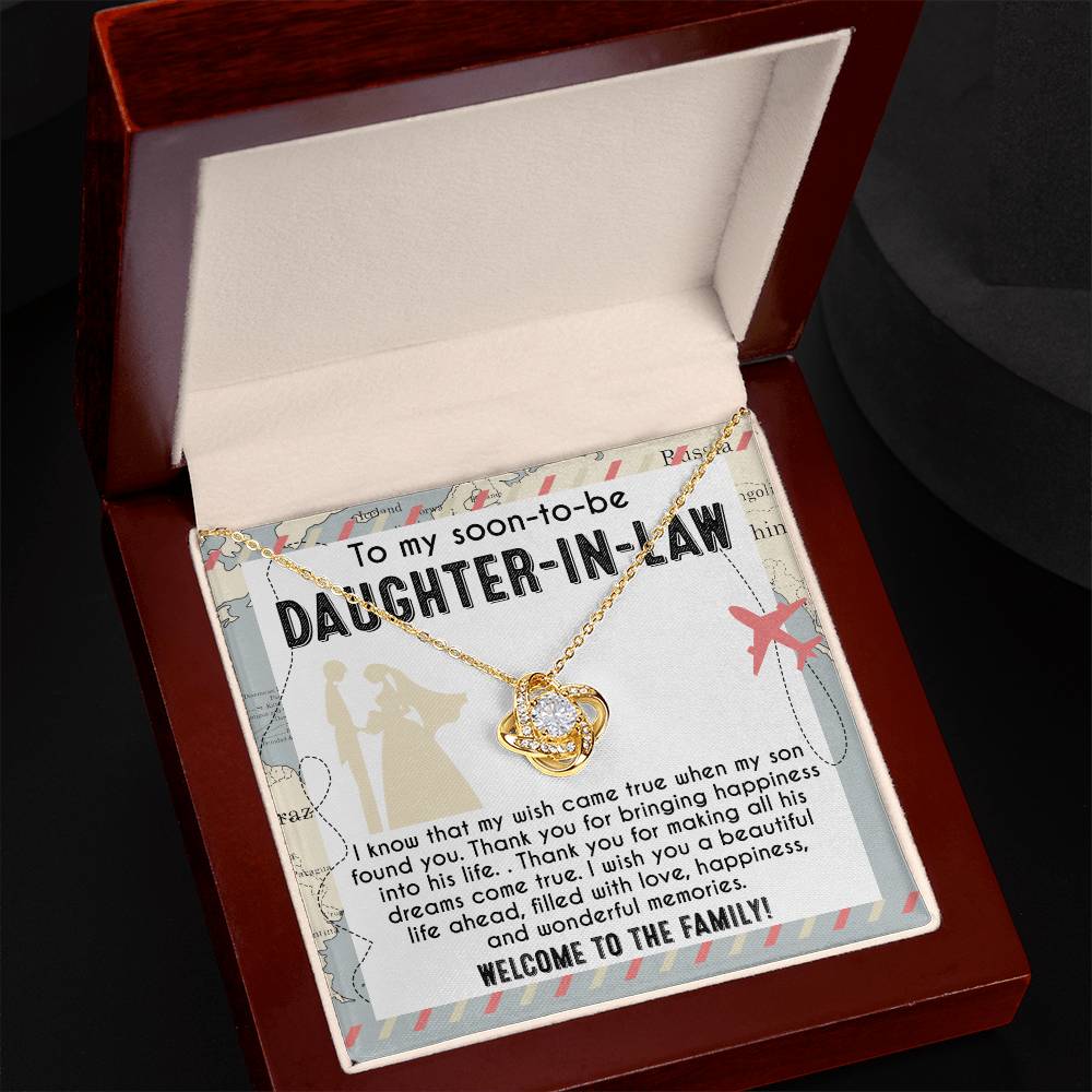 A To Daughter-in-Law, Into His Life - Love Knot Necklace with an intertwined design is displayed on a card that reads: "To my soon-to-be daughter-in-law. I wish you a beautiful life ahead, filled with love, happiness, and wonderful memories. Welcome to the family!" Available in white gold or yellow gold finish.