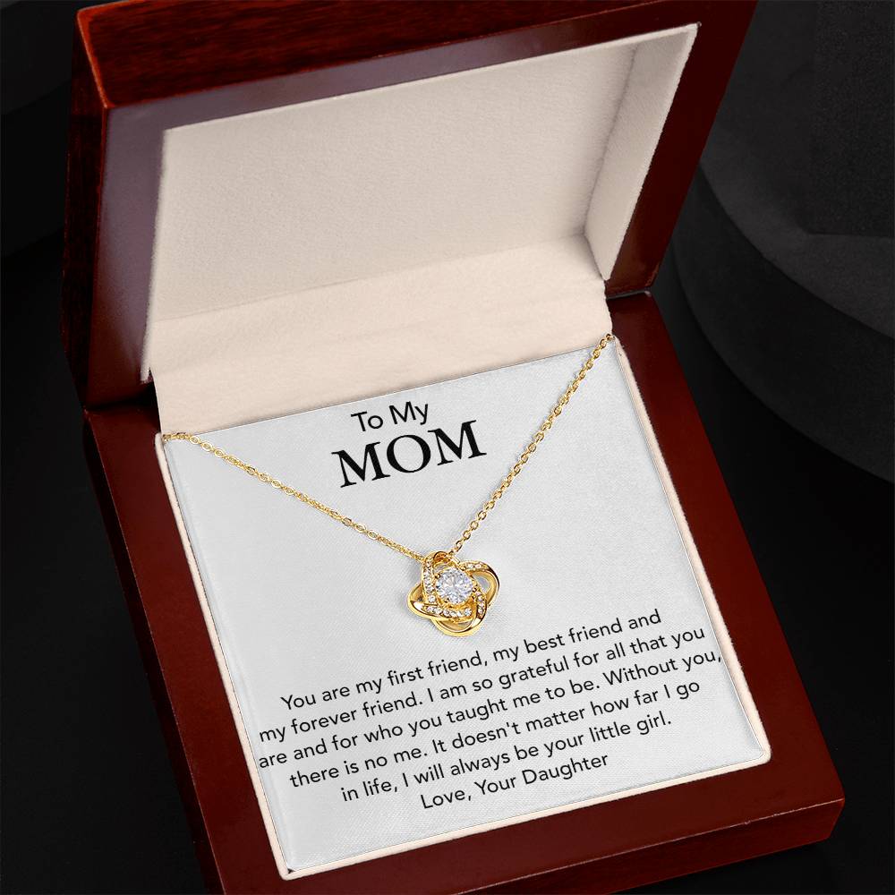 A gold To My Mom, You Are My First Friend - Love Knot Necklace with a heart-shaped pendant is displayed inside a red jewelry box that has a heartfelt message addressed "to my mom" from a daughter. (Brand Name: ShineOn Fulfillment)