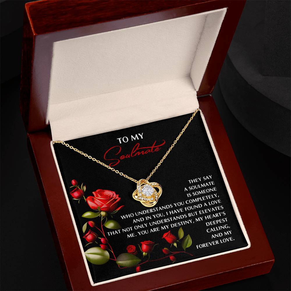 The Soulmate-Deepest Calling Love Knot Necklace, adorned with cubic zirconia crystals, elegantly rests in a wooden box featuring red rose illustrations and the message "To My Soulmate," making it a perfect personalized gift symbolizing love and commitment.