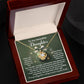 The Daughter-Incredible Uniqueness - Love Knot Necklace features a heart-shaped pendant elegantly displayed in an open jewelry box. The box contains a heartfelt message for a daughter, making it the perfect personalized gift, complemented by premium cubic zirconia for added elegance and sparkle.