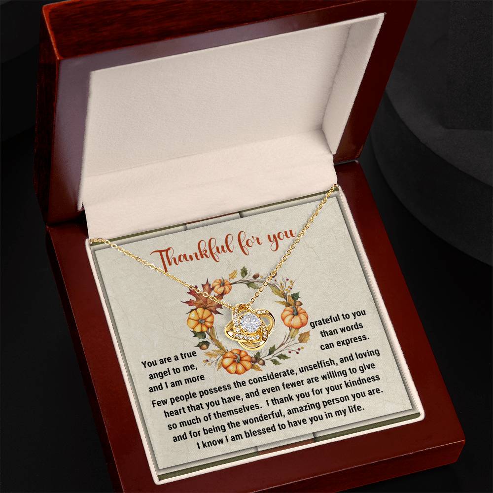 A Thanksgiving-The Wonderful - Love Knot Necklace, featuring intertwined hearts embellished with sparkling cubic zirconia crystals, is elegantly showcased in an open jewelry box. The inside cover is adorned with the message "Thankful for you," beautifully surrounded by a fall-themed design, making it an ideal personalized gift for someone special.