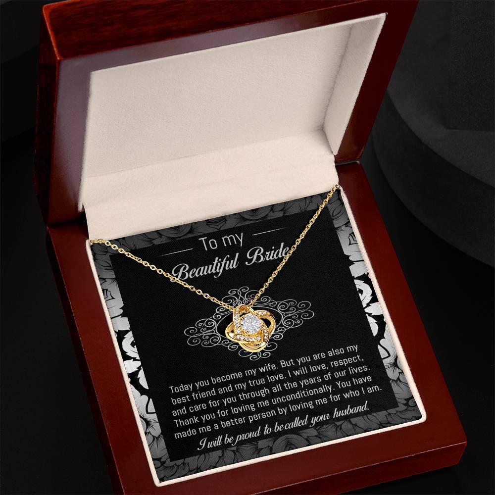 The "To Bride, My True Love - Love Knot Necklace" with a diamond pendant is displayed in a black and white box adorned with a floral pattern. The box, featuring cubic zirconia crystals, includes a heartfelt message addressed to "my beautiful bride" from her husband.