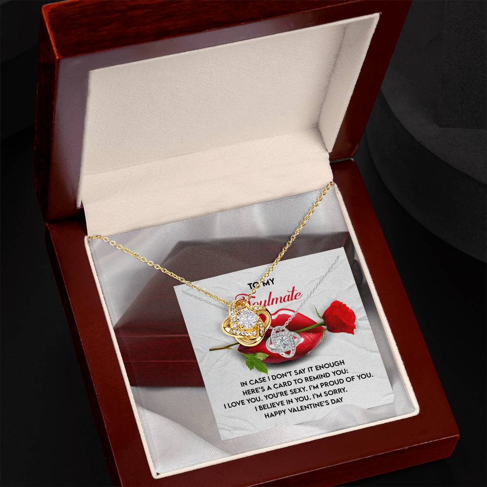 The Soulmate-Don’t Say It - Love Knot Necklace, embellished with sparkling cubic zirconia crystals, comes in a wooden box. It sits on a card with a Valentine's Day message and an image of a red rose, symbolizing an unbreakable bond of love.