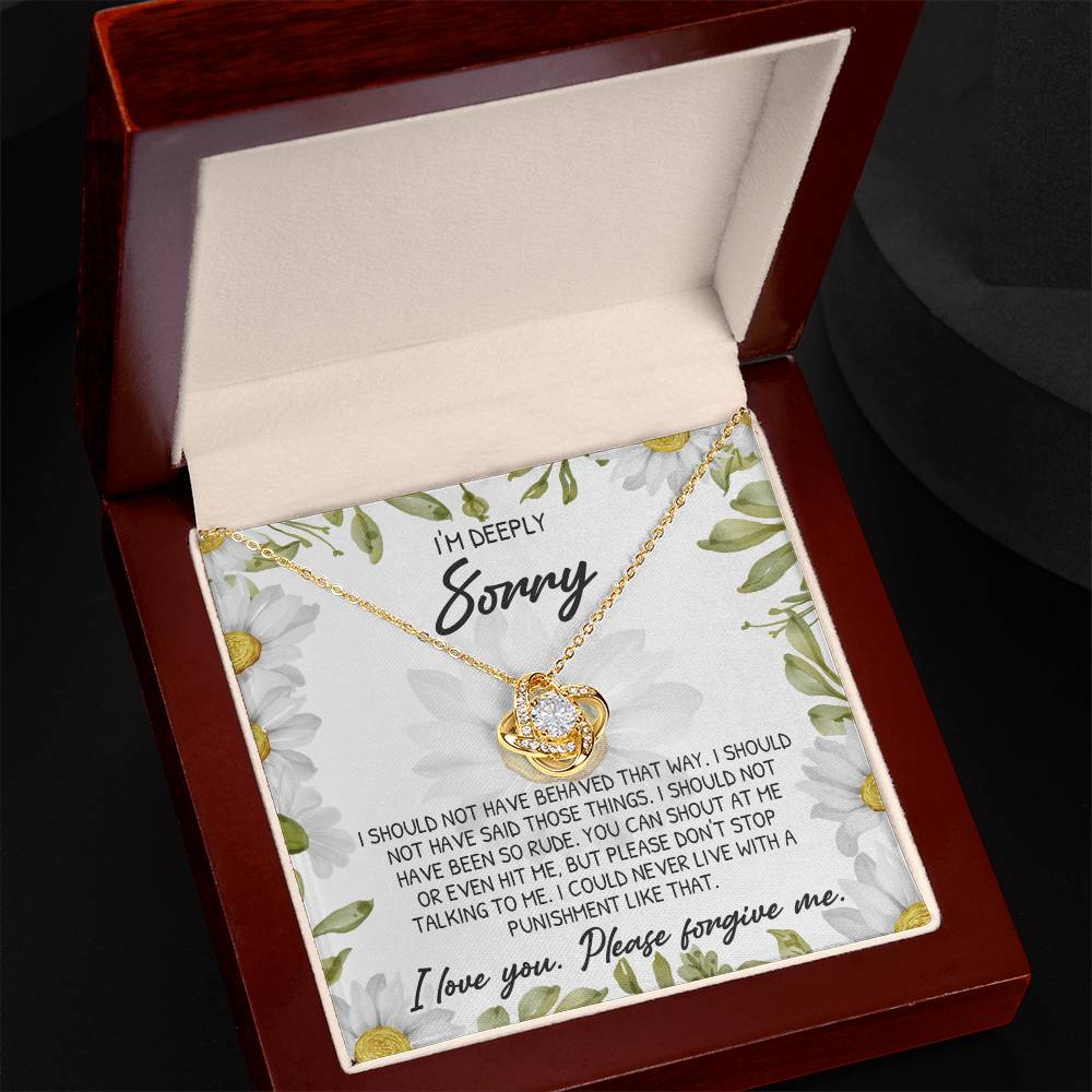 A 14k white gold heart-shaped "Sorry-Please Don't Stop - Love Knot Necklace" with a diamond is elegantly presented in an open gift box, accompanied by a card conveying an apology message that expresses regret and seeks forgiveness.