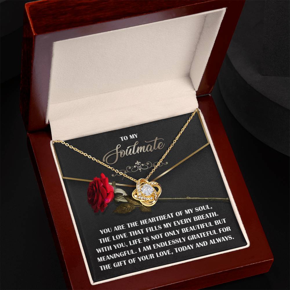 The Soulmate-My Every Breath Love Knot Necklace, with a cubic zirconia crystal pendant, is beautifully showcased in an open jewelry box. Accompanied by a fabric red rose and a touching message, it serves as an ideal personalized gift for your soulmate.