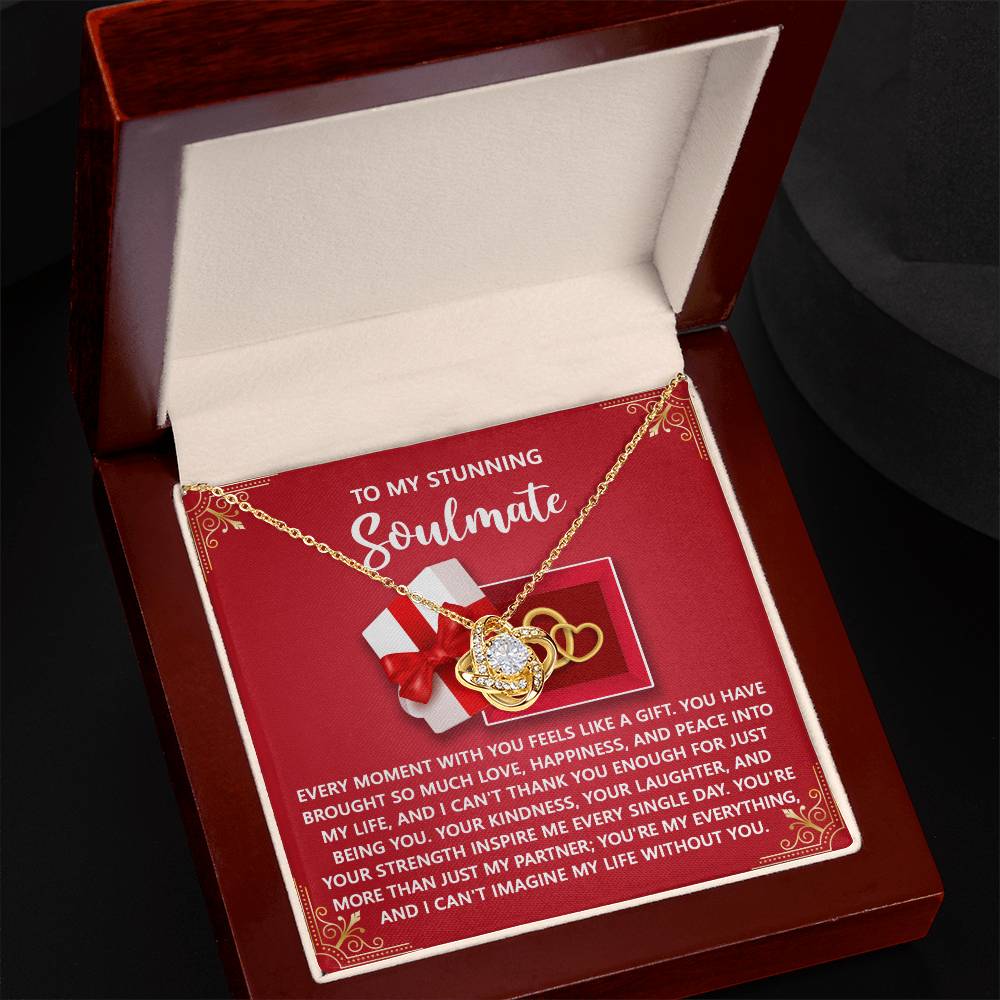 The Soulmate-Like A Gift - Love Knot Necklace comes in a gift box with cubic zirconia crystals and a "To my stunning soulmate" card. It features intertwined rings and a heartfelt message, making it an ideal personalized gift.