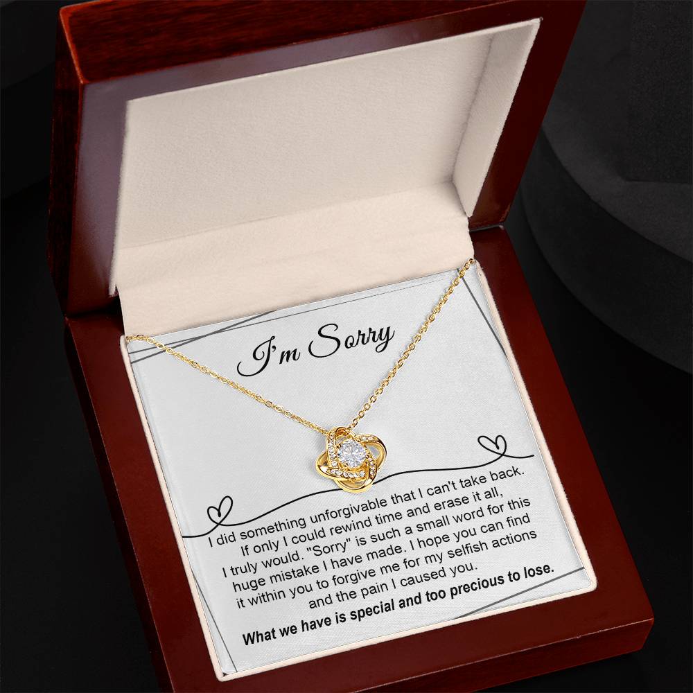 The Sorry-Breaking My Heart - Love Knot Necklace, featuring a gold finish and embellished with sparkling cubic zirconia crystals, is presented on a heartfelt message card that expresses deep regret for a mistake and seeks forgiveness.