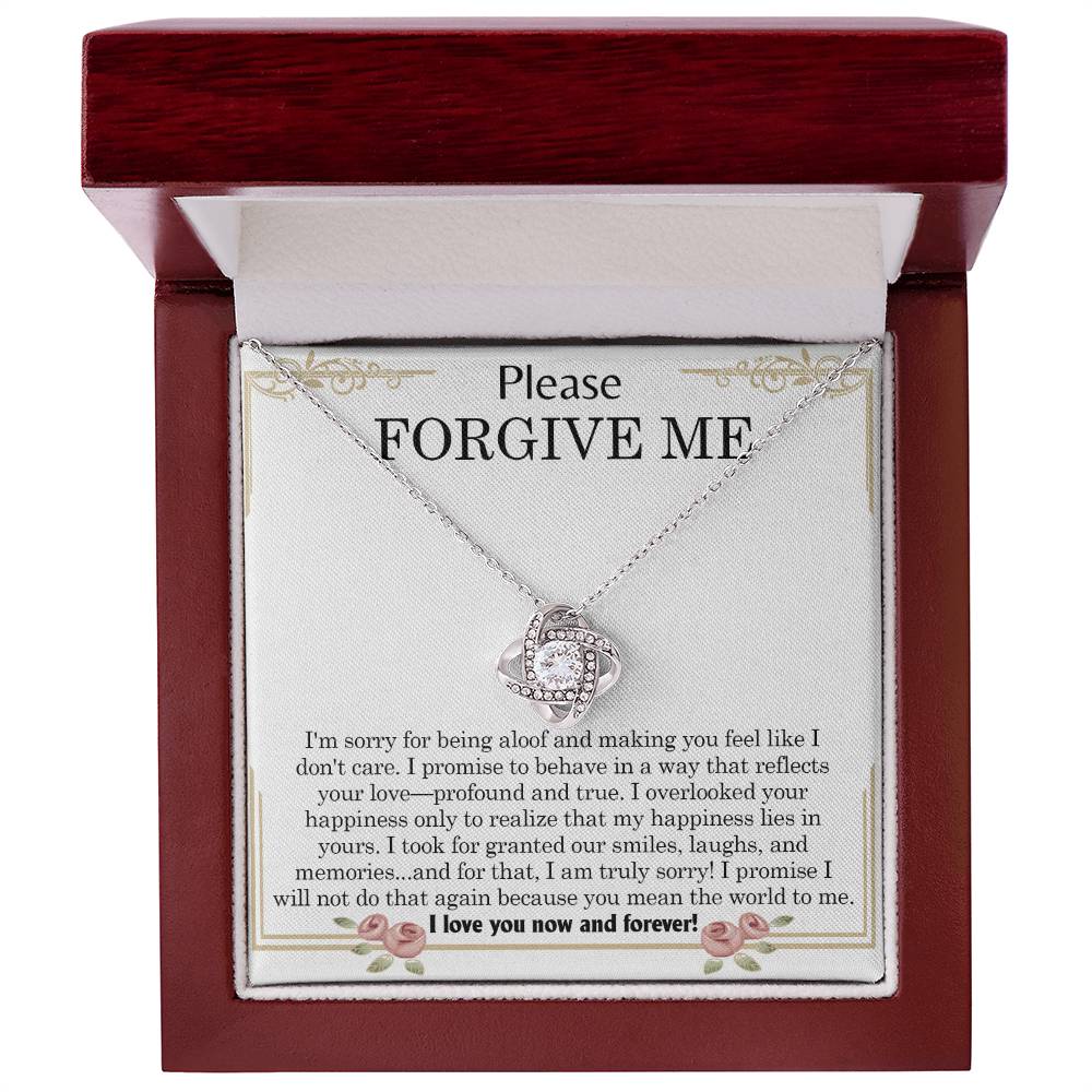 The "Sorry, Profound And True - Love Knot Necklace," featuring an intertwined heart pendant, is elegantly displayed in a box. The message "Please FORGIVE ME!" along with a heartfelt apology note is printed inside the box and beautifully accentuated by cubic zirconia crystals.