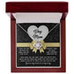 The Dog Mom-In Every Way - Love Knot Necklace, featuring "Dog Mom" on a heart pendant, is displayed in a red jewelry box with an open lid showing a heartfelt message. It elegantly celebrates dog moms and is adorned with sparkling cubic zirconia crystals.
